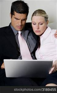 Close-up of a businessman and a businesswoman using a laptop