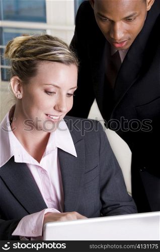 Close-up of a businessman and a businesswoman using a laptop