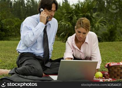 Close-up of a businessman and a businesswoman working on a laptop