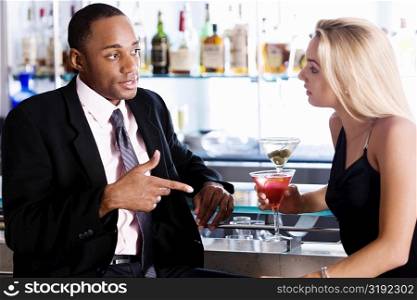 Close-up of a businessman and a young woman at a bar counter