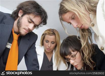 Close-up of a businessman and three businesswomen discussing