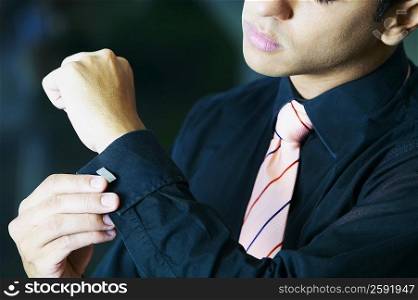 Close-up of a businessman buttoning his cuff