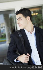 Close-up of a businessman carrying a bag and smiling