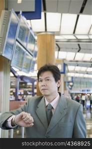 Close-up of a businessman checking the time at an airport
