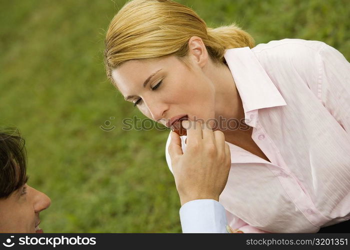 Close-up of a businessman feeding a cherry to a businesswoman