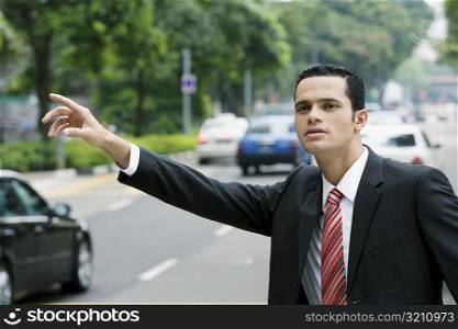Close-up of a businessman hailing for a vehicle