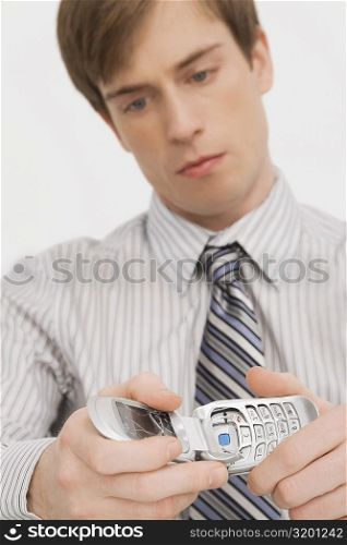 Close-up of a businessman holding a broken mobile phone
