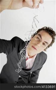 Close-up of a businessman holding a chain of paper clips