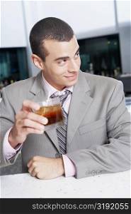 Close-up of a businessman holding a glass of cocktail in a bar