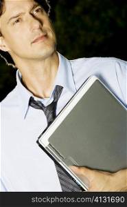 Close-up of a businessman holding a laptop