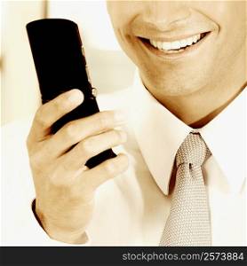 Close-up of a businessman holding a mobile phone and smiling