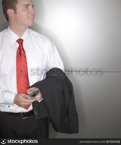 Close-up of a businessman holding a mobile phone and smiling