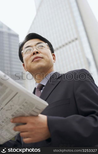 Close-up of a businessman holding a newspaper