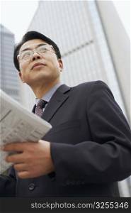 Close-up of a businessman holding a newspaper