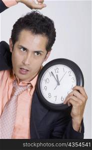 Close-up of a businessman holding a noose and a clock