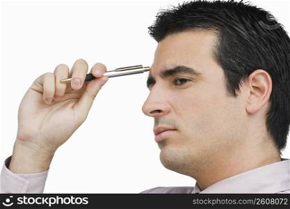 Close-up of a businessman holding a pen and thinking