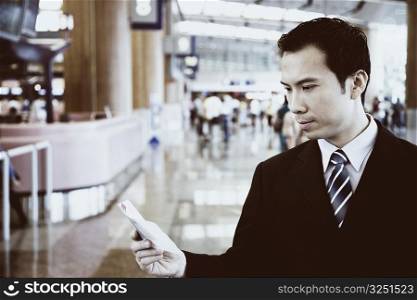 Close-up of a businessman holding a pocket diary at an airport