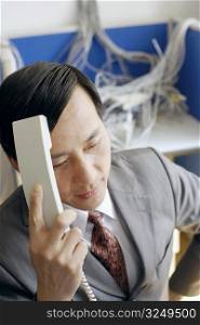 Close-up of a businessman holding a telephone receiver in a server room