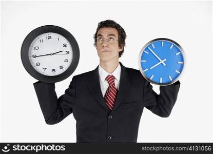 Close-up of a businessman holding clocks