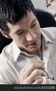 Close-up of a businessman holding eyeglasses