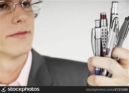 Close-up of a businessman holding pens