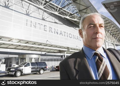 Close-up of a businessman in front of an airport