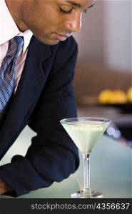Close-up of a businessman looking at a glass of martini
