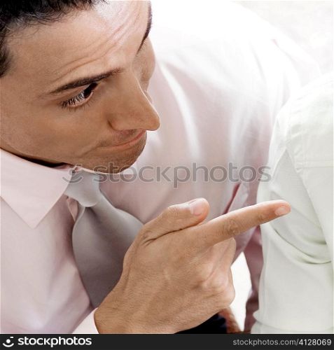 Close-up of a businessman pointing towards another businessman
