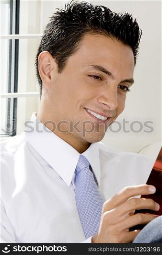 Close-up of a businessman reading a magazine