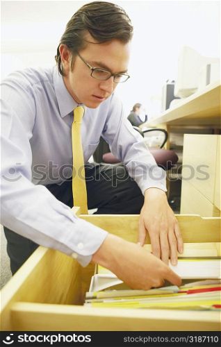 Close-up of a businessman searching for a file in drawer