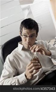 Close-up of a businessman sipping a drink with a straw