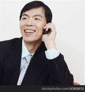 Close-up of a businessman sitting on a couch and talking on a mobile phone