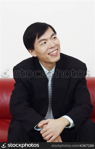 Close-up of a businessman sitting on a couch and thinking