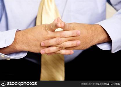 Close-up of a businessman sitting with his hands clasped