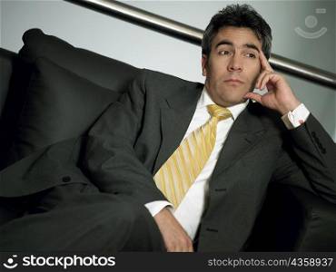 Close-up of a businessman sitting with his legs crossed at the knee