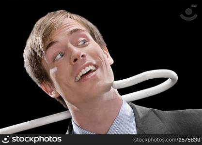 Close-up of a businessman smiling and being pulled by a cane