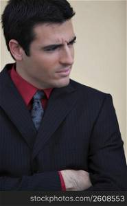 Close-up of a businessman standing with his arms crossed and looking away