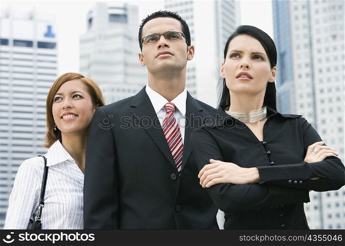 Close-up of a businessman standing with two businesswomen