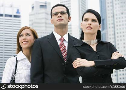 Close-up of a businessman standing with two businesswomen