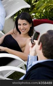 Close-up of a businessman taking a picture of a businesswoman