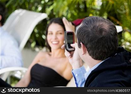 Close-up of a businessman taking a picture of a businesswoman