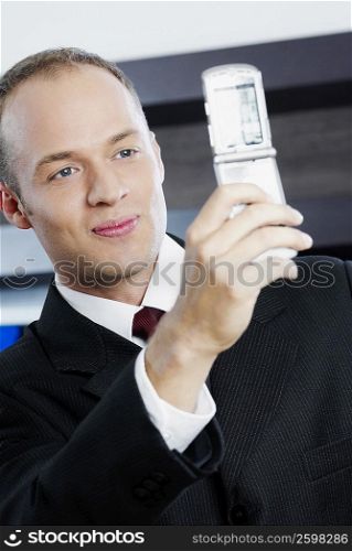 Close-up of a businessman taking his photograph with a mobile phone
