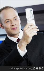 Close-up of a businessman taking his photograph with a mobile phone