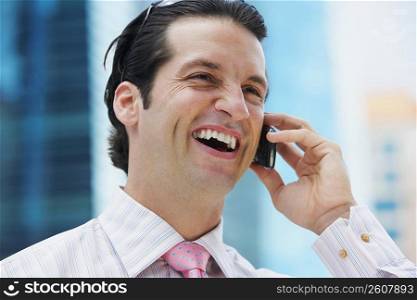 Close-up of a businessman talking on a mobile phone and laughing