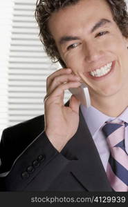 Close-up of a businessman talking on a mobile phone and smiling