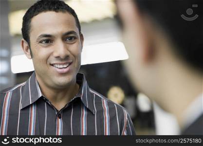 Close-up of a businessman talking to another businessman and smiling