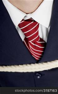 Close-up of a businessman tied up with rope