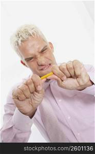 Close-up of a businessman trying to break a pencil