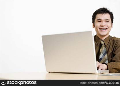 Close-up of a businessman using a laptop and smiling