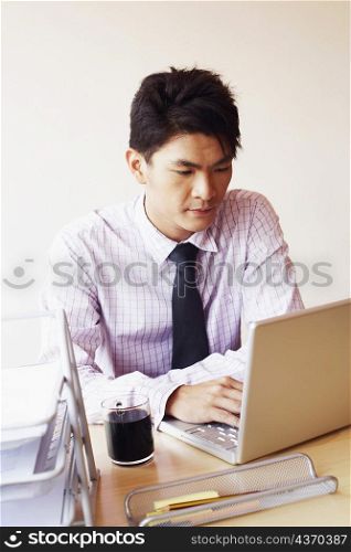 Close-up of a businessman using a laptop in an office
